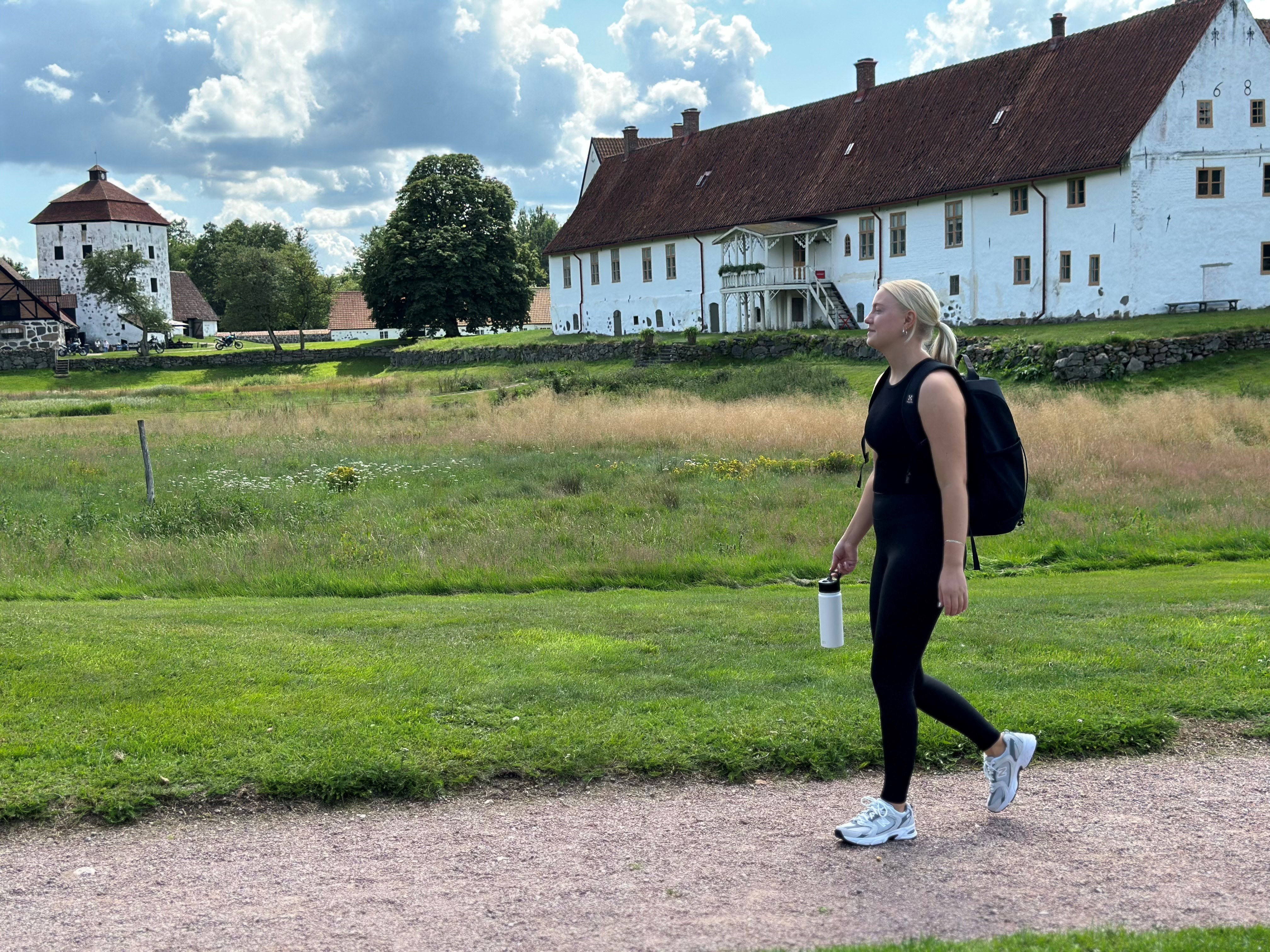 En tjej vandrar genom parken invid Hovdala slott.