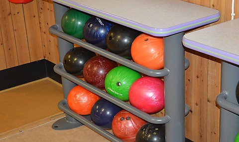 Ett ställ med många bowlingklot i många glada färger.