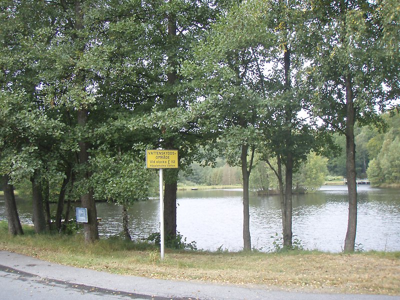 Bid på skylt vid vattendrag som visar att det är ett vattenskyddsområde.